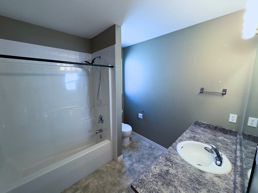 A bathroom with a sink, toilet, and bathtub.