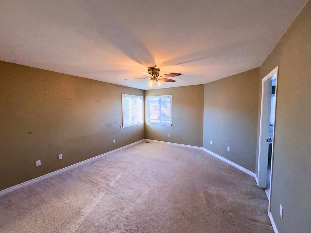 A room with a ceiling fan and a window.