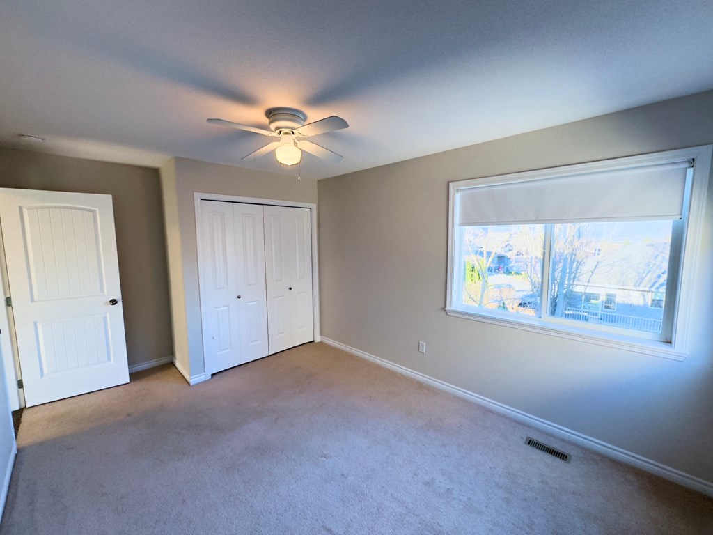 A room with a ceiling fan and a window.