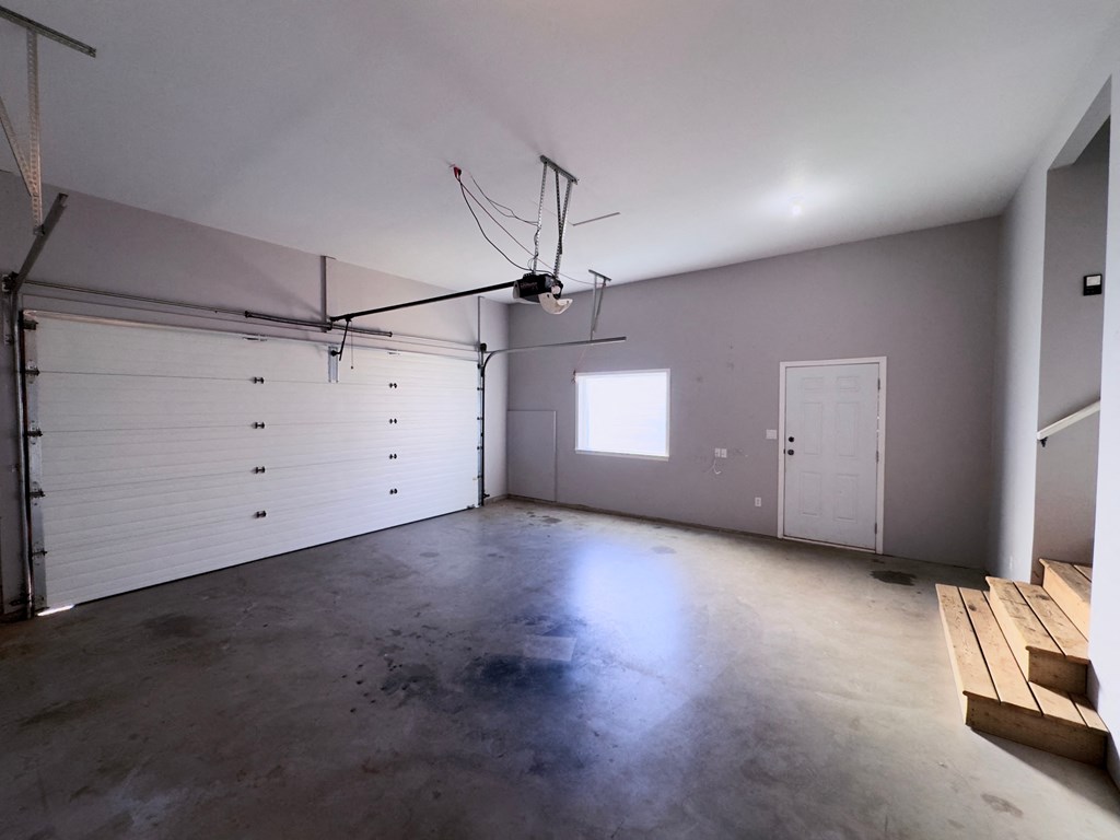 A spacious garage with a white ceiling and a window.