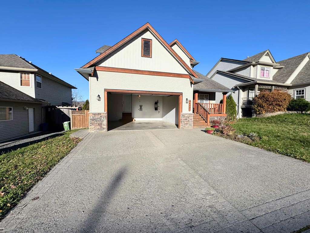 A house with a garage and a driveway in front.