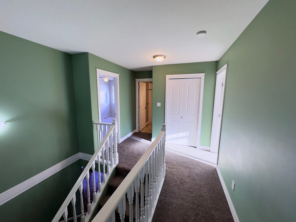 A hallway with green walls and a white door.