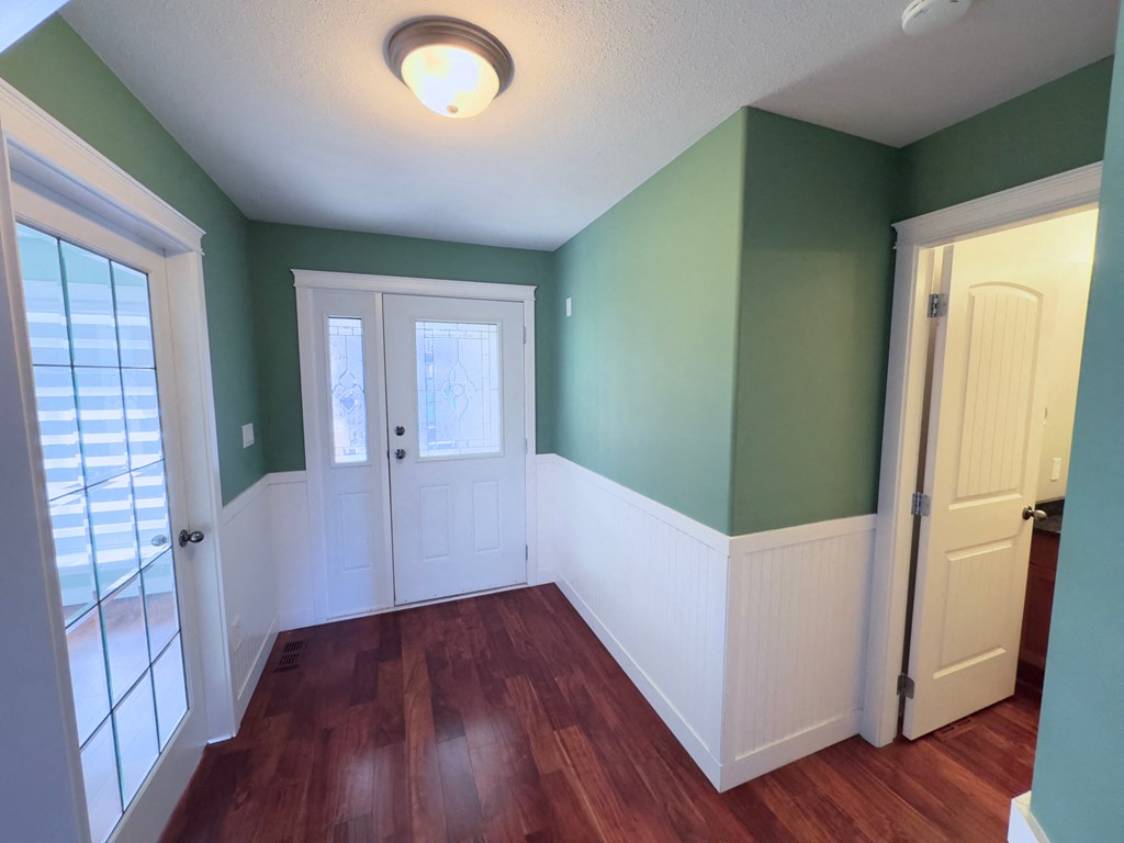 A room with green walls and wood floors.