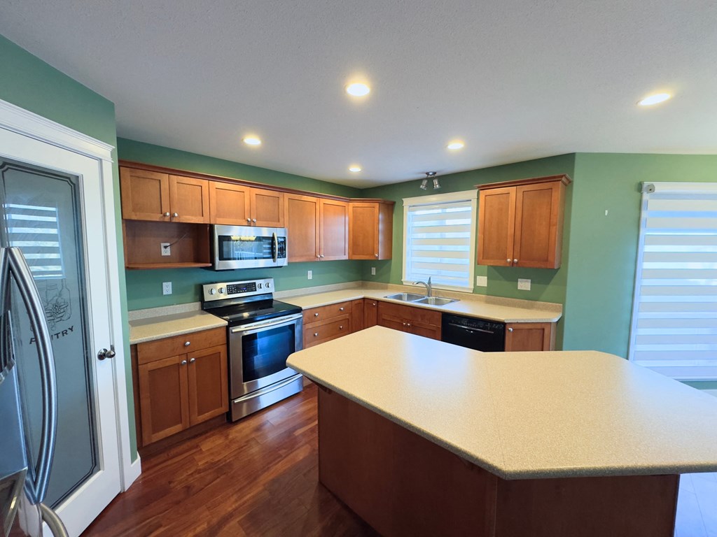 A kitchen with wooden cabinets and a stove top oven.