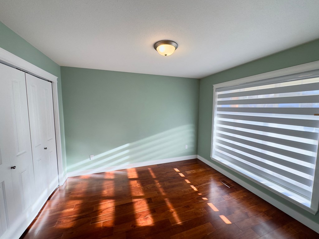 A room with a wooden floor and a white door.
