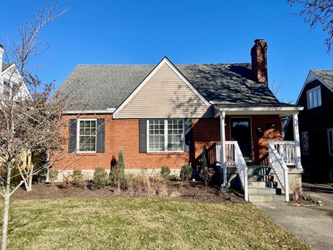 A red brick house with a white porch.