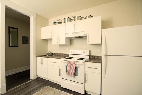 A kitchen with white appliances and cabinets.