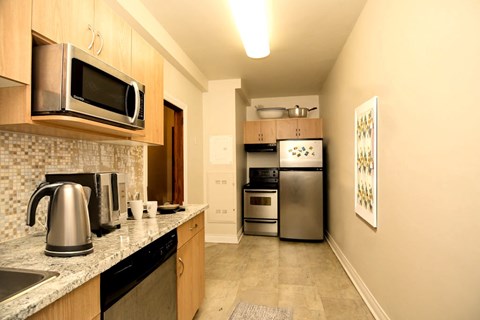 A kitchen with a stainless steel refrigerator, microwave, and oven.