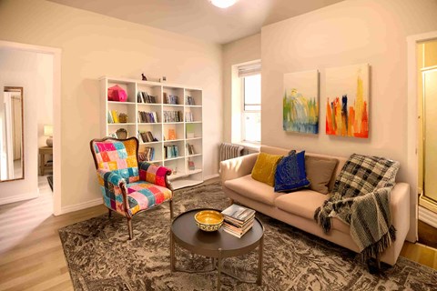 A living room with a couch, chair, and bookshelf.