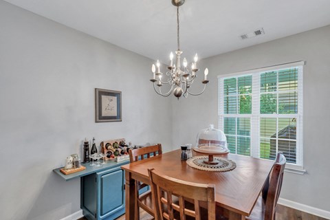 A dining room with a wooden table and chairs.