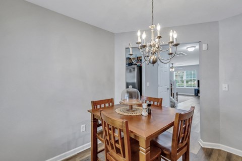 A dining room with a wooden table and chairs.