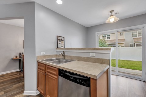 A kitchen with a stainless steel dishwasher and a sink.