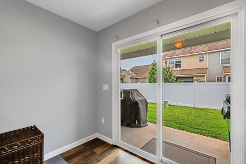 A room with a sliding glass door leading to a backyard.