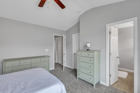 A bedroom with a bed, dresser, and mirror.
