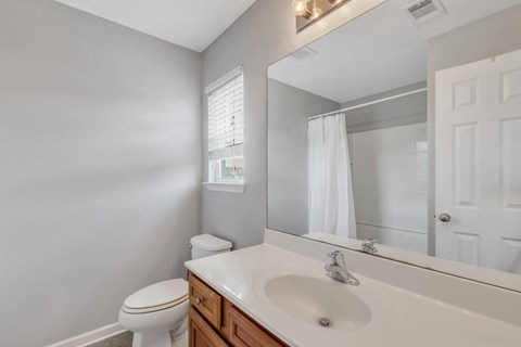 A white toilet sits next to a white sink in a bathroom.