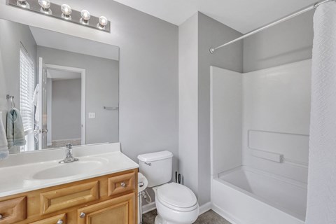 A white bathroom with a toilet, sink, and shower.