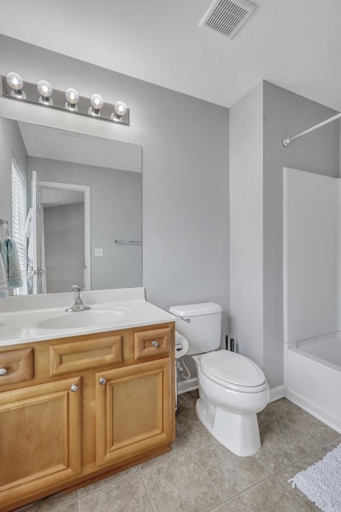 A white toilet sits next to a sink in a bathroom.