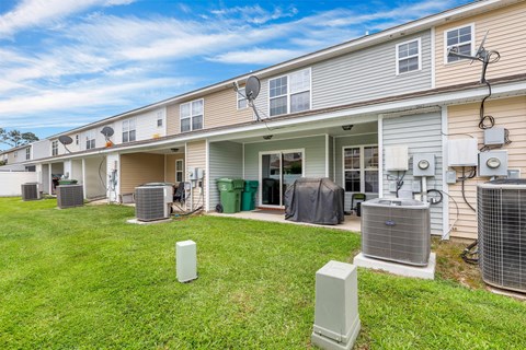 A row of houses with air conditioning units in front.
