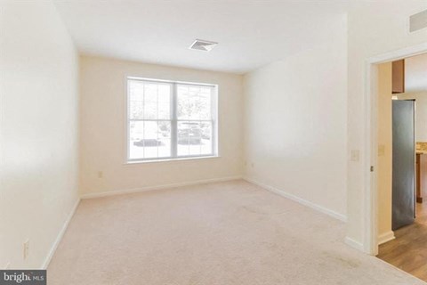 A spacious room with a window and a door.