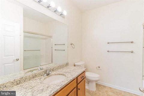 A bathroom with a marble countertop and a walk-in shower.