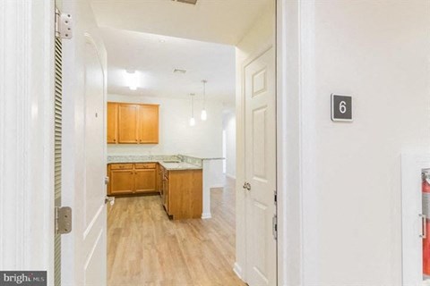 A bright hallway with wooden floors and white walls.