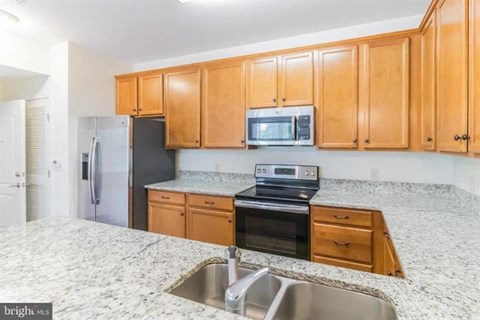 A kitchen with wooden cabinets and a granite countertop.