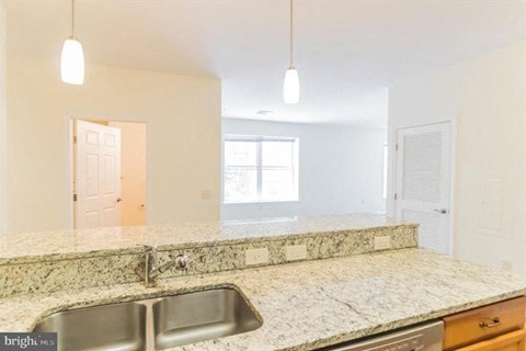 A kitchen with granite countertops and a stainless steel sink.
