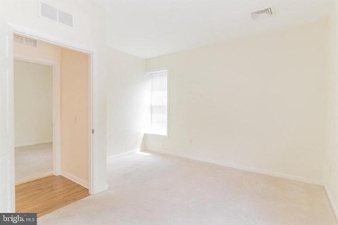 A large empty room with a door and a window.