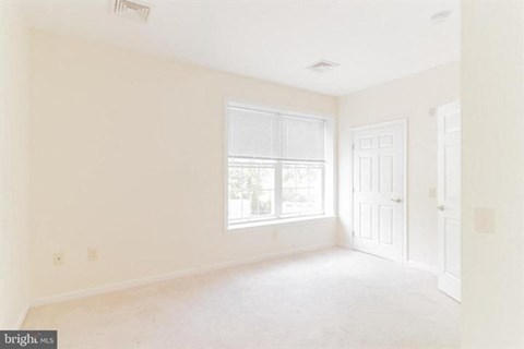 A bright, empty room with a window and a door.
