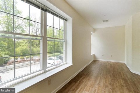 A room with a large window and wooden flooring.