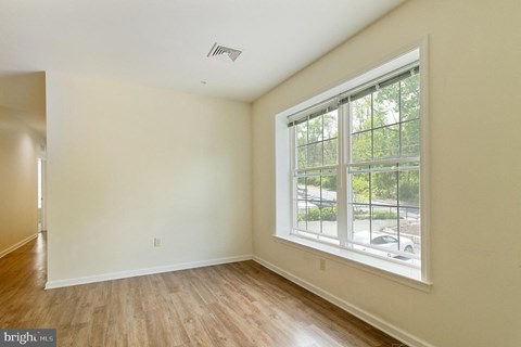 A room with a window overlooking a parking lot.