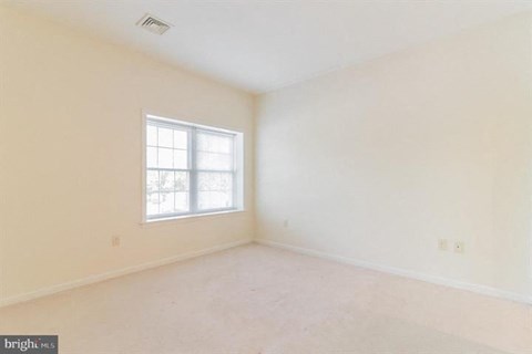 A room with a window and a ceiling fan.