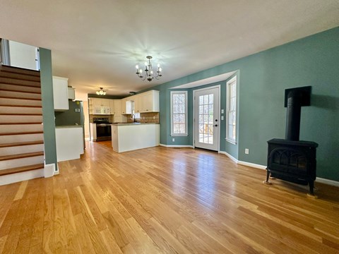 A living room with a wood floor and a fireplace.
