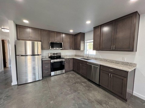 A kitchen with brown cabinets and a granite countertop.