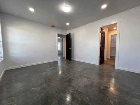 A spacious room with a dark floor and white walls.