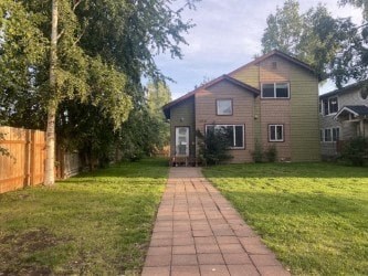 A house with a brown fence and a green lawn.