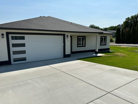 A two-car garage with a white exterior and a black roof.