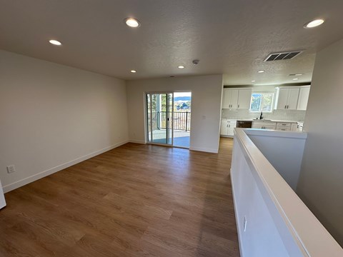 A room with wooden flooring and white walls.