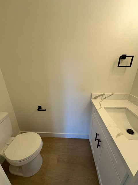 A white toilet sits next to a white sink in a small bathroom.