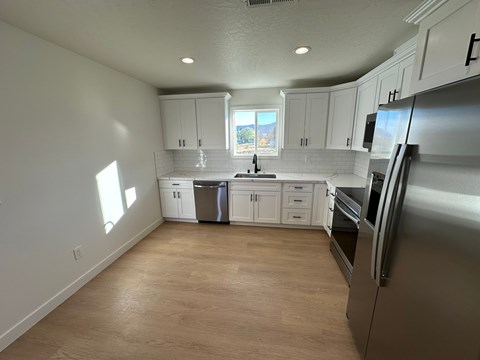 A kitchen with white cabinets and stainless steel appliances.