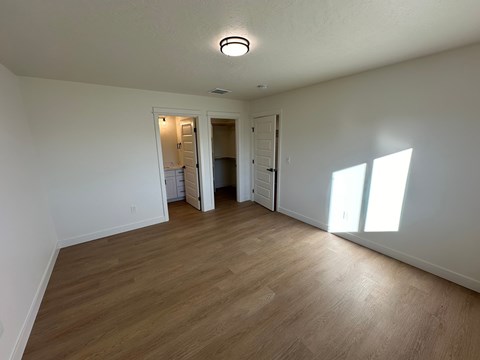 A room with wooden flooring and white walls.