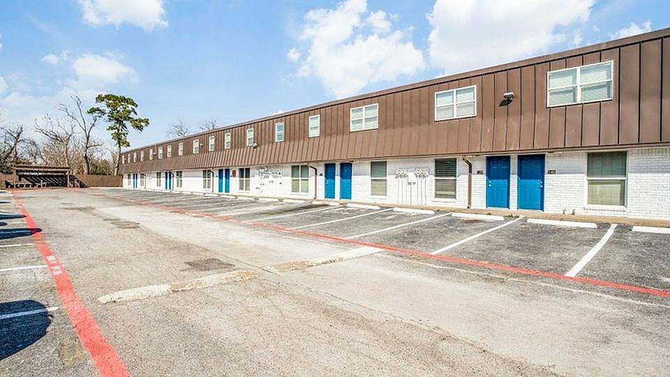 A parking lot with a building in the background.