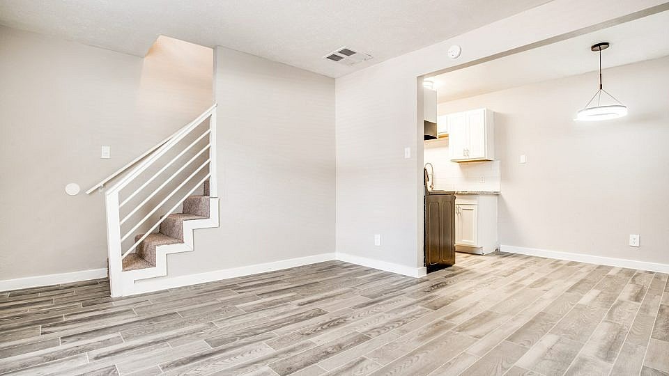 A room with a staircase and a cabinet.