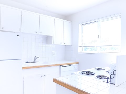 A white kitchen with a stove top oven.