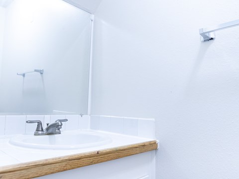 A white sink with a silver faucet in a bathroom.