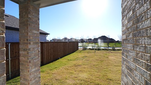 A backyard with a wooden fence and a grassy area.