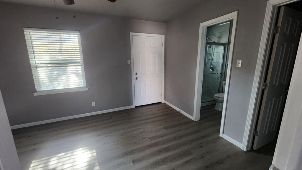 A room with a white door and a window with blinds.