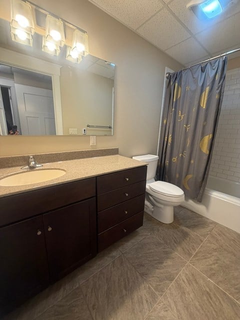A bathroom with a sink, toilet, and a shower curtain.