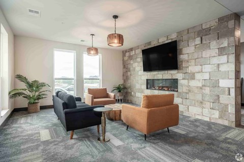 A living room with a stone wall and a fireplace.