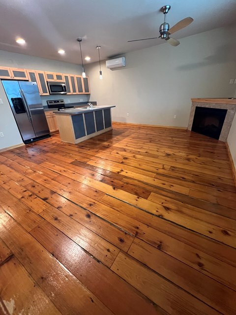 A kitchen with wooden floors and a fireplace.